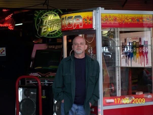 David standing indoors beside colorful lights