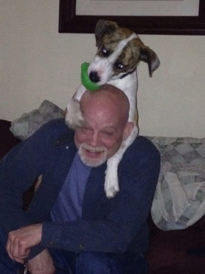 David smiling with a small dog perched on his shoulders